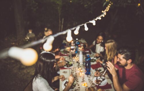 Group of friends making barbecue in the backyard at dinner time